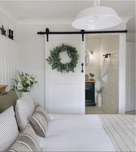 Load image into Gallery viewer, Bedroom with a sliding barn door.
