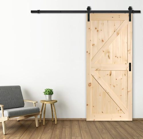 Wooden sliding barn door in a room with a chair and small table.
